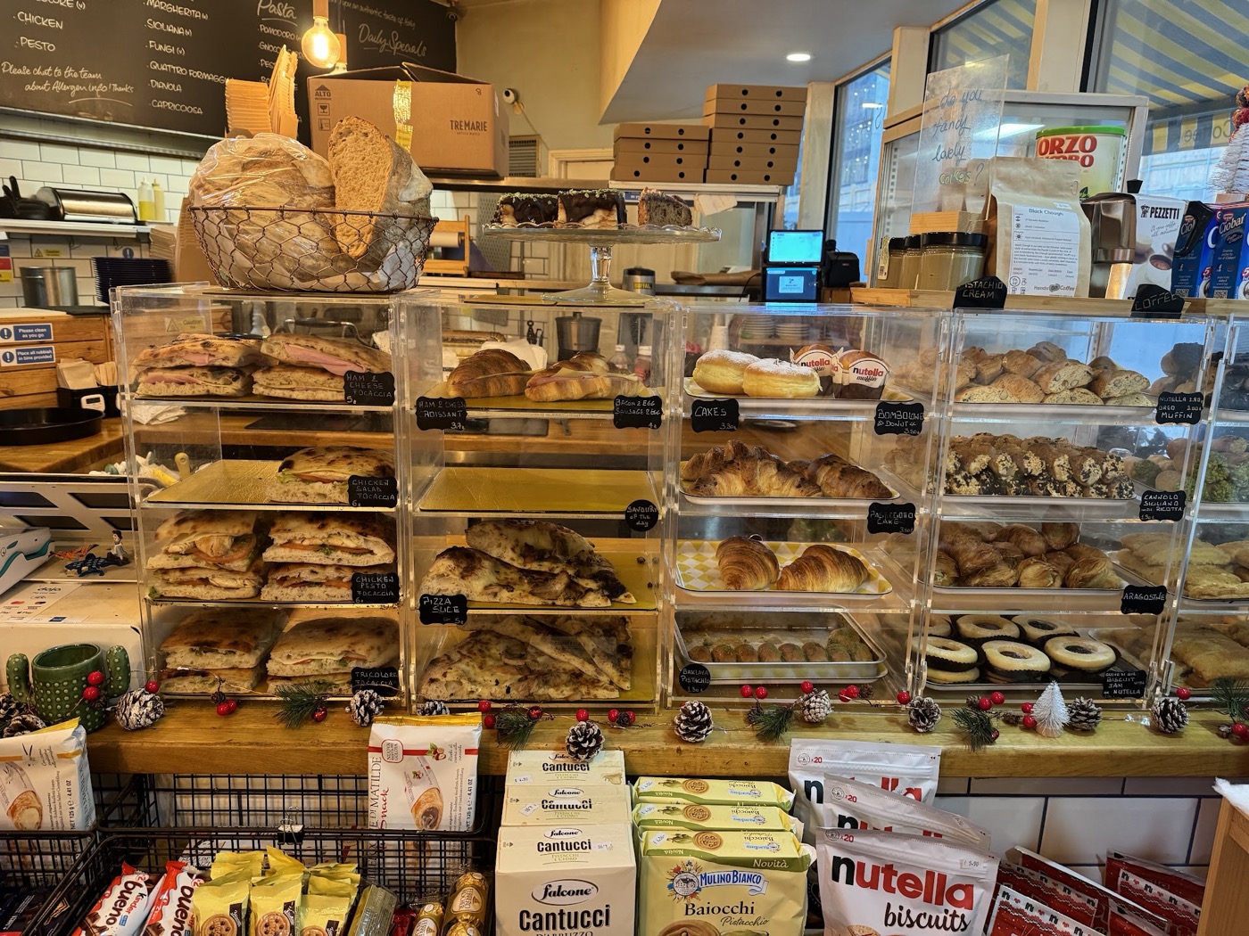 Focaccia sandwiches, croissants and cannoli in the display cases at Neama