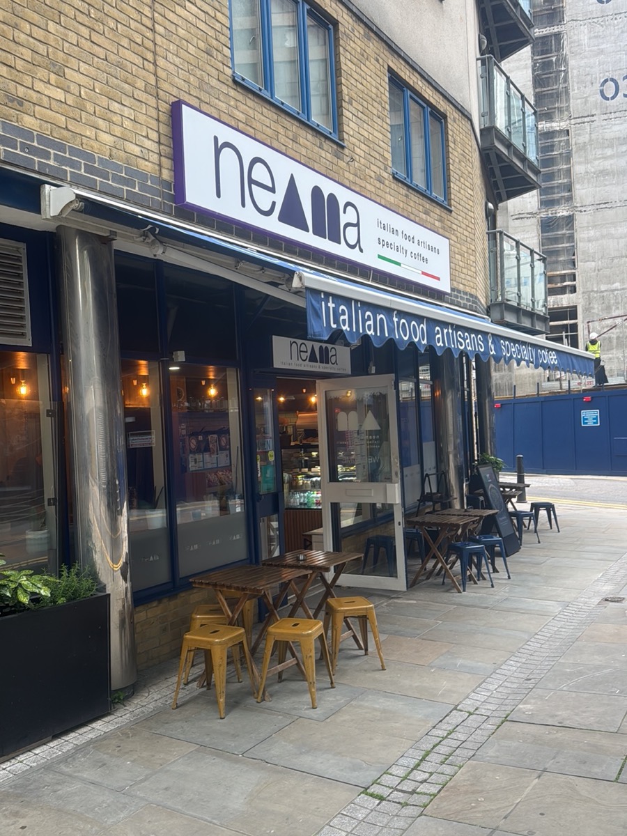 Neama's shopfront on Cuba Street with its navy awning and pavement tables